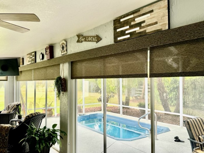 Woven wood shades on sliding glass doors overlooking a pool