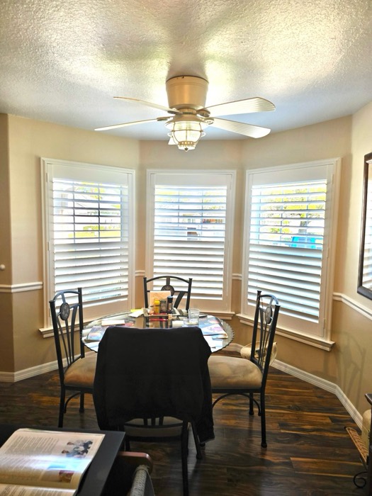 Plantation shutters on a three-window bay in a breakfast nook