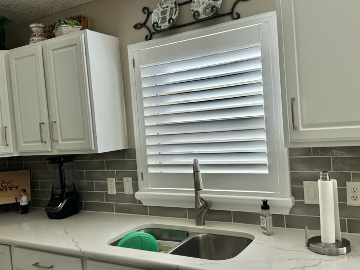 Plantation shutter on a kitchen window above the sink