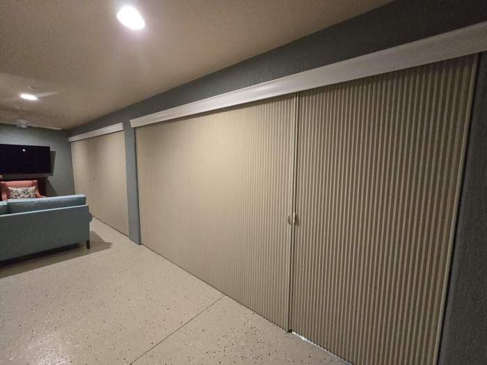 Panel track fabric shades covering a wide wall of windows