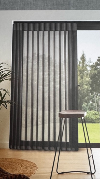 Wave sheer curtain at a sunlit sliding patio door