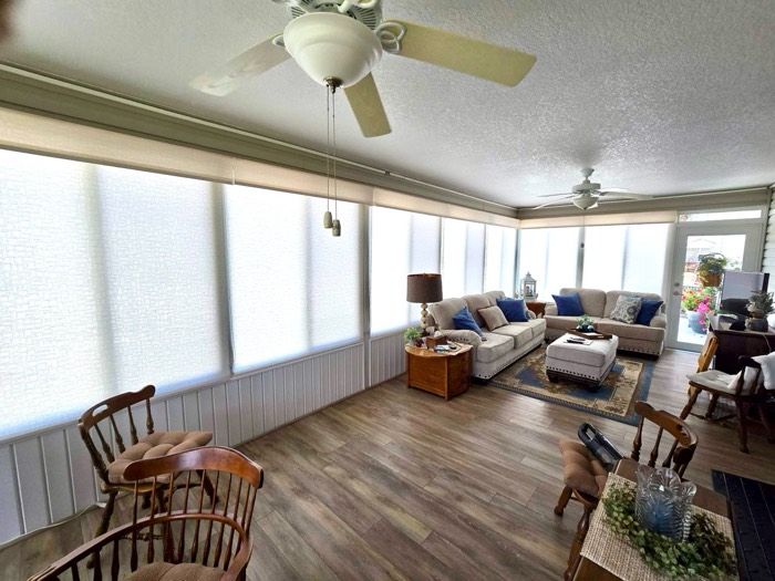 Solar roller shades wrapping around a sunroom's windows